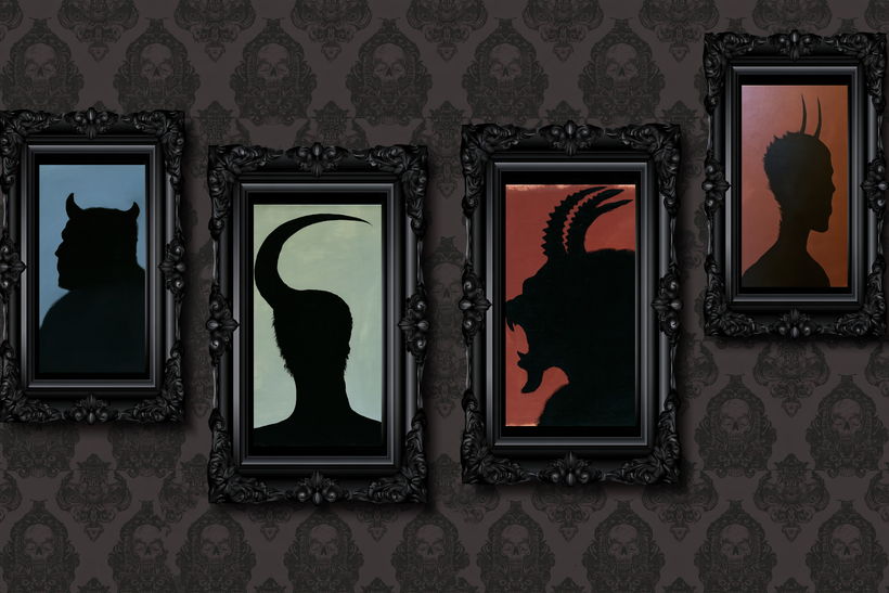 Four horned silhouette portraits in ornate frames on dark wallpaper