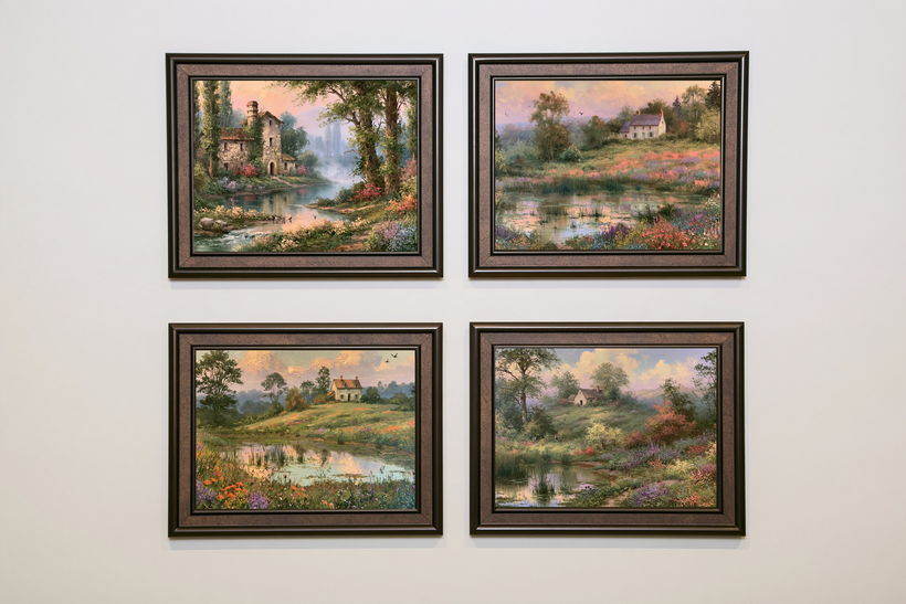 Four framed cottage-and-pond paintings in dark frames