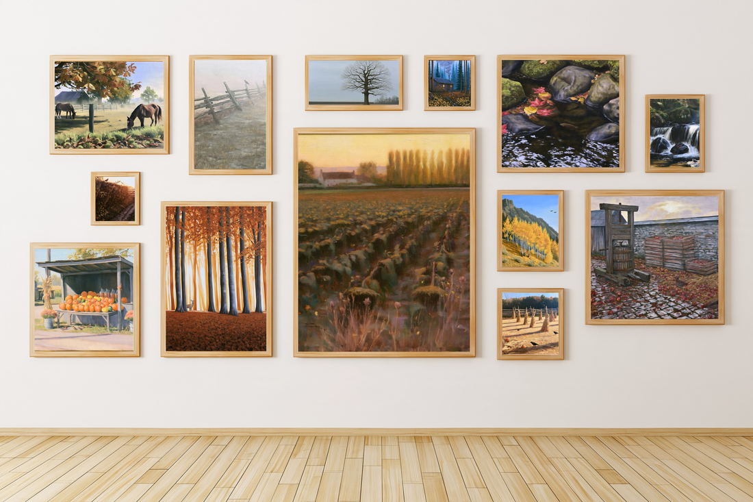 Thirteen framed autumn paintings arranged as a gallery wall
